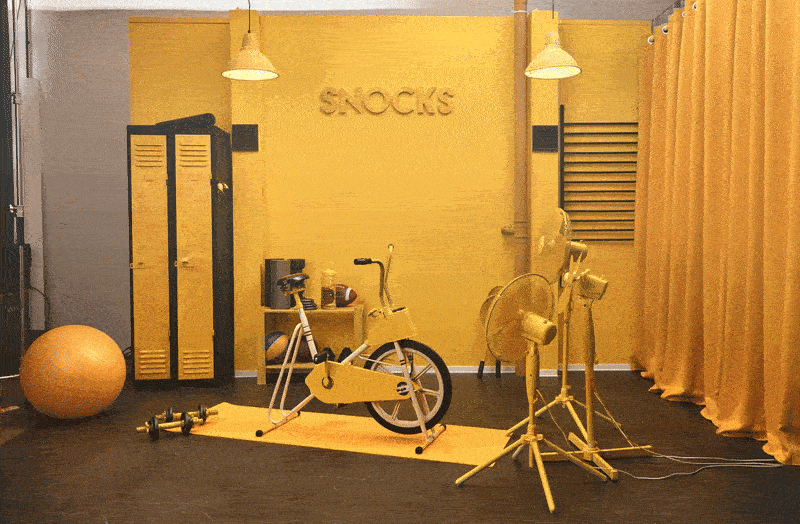 Set design for the Snocks Black Friday campaign featuring a monochromatic yellow studio space with props and brand elements GIF