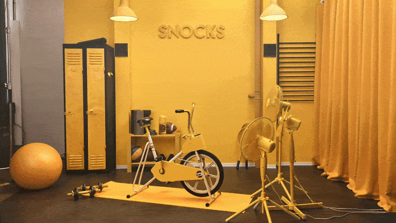 Set design for the Snocks Black Friday campaign featuring a monochromatic yellow studio space with props and brand elements GIF